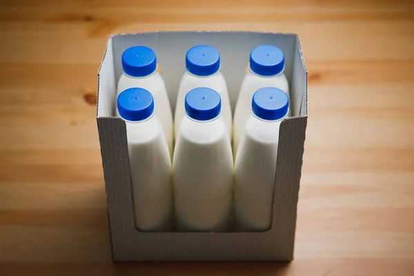 Botellas Leche Caja Cartón Sobre Mesa Madera —  Fotos de Stock