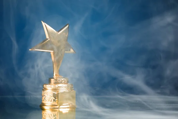 Troféu Estrela Ouro Fumaça Fundo Azul — Fotografia de Stock