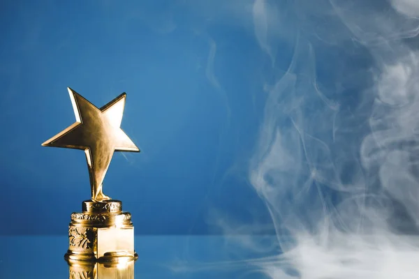 Troféu Estrela Ouro Fumaça Fundo Azul — Fotografia de Stock