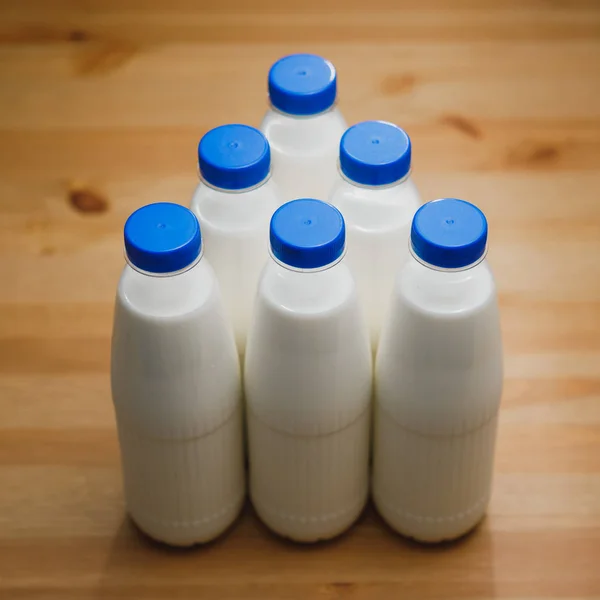 Молочні Пляшки Дерев Яному Столі — стокове фото
