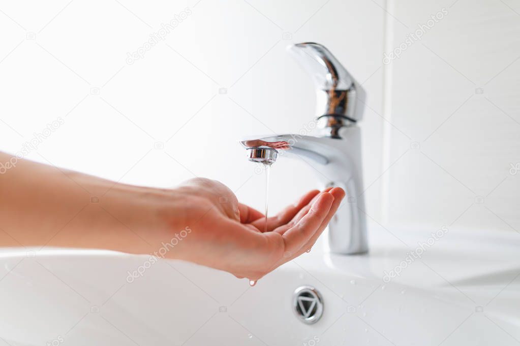 hand under faucet with low pressure water stream