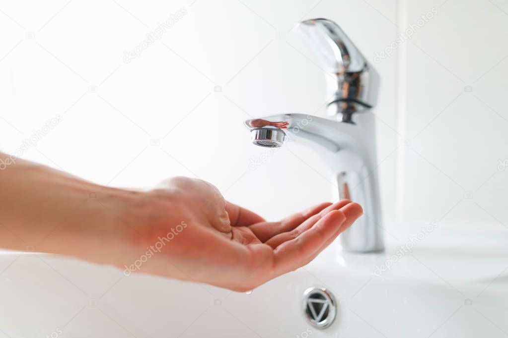 hand under faucet without water