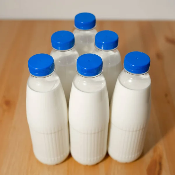 Garrafas de leite na mesa de madeira — Fotografia de Stock