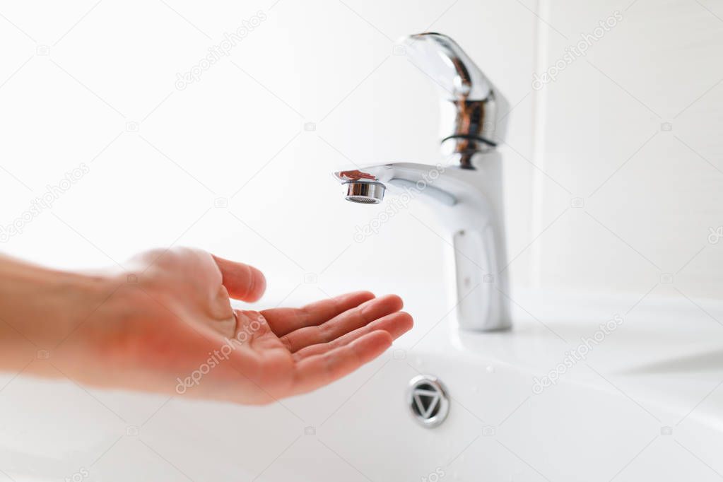 hand under faucet without water