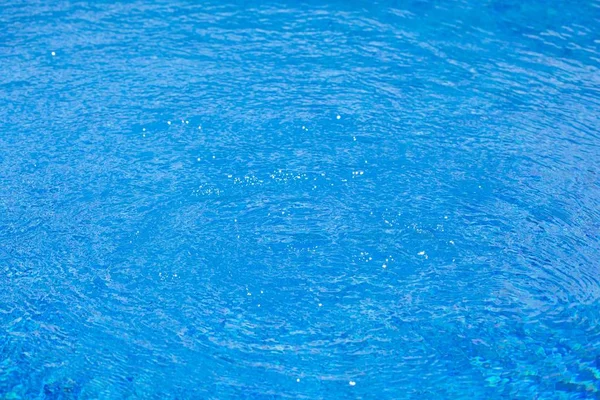 Water ripples in swimming pool, blue background — Stock Photo, Image