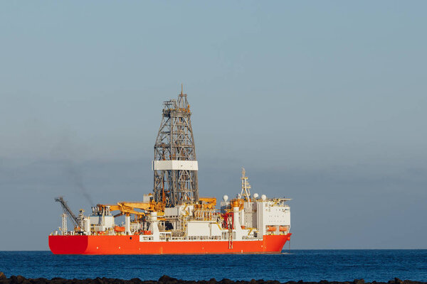 offshore oil and gas drillship, blue ocean background