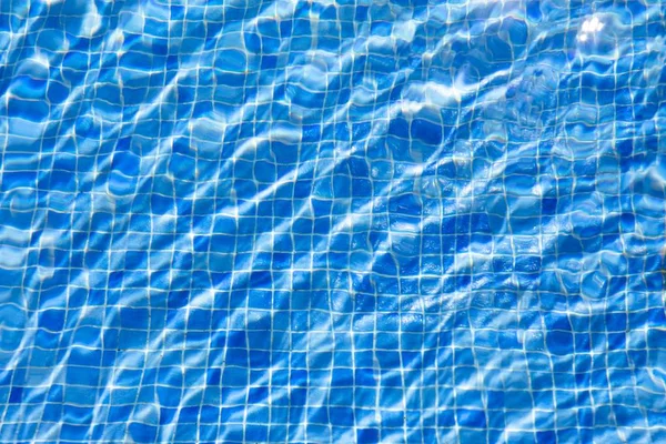 Water ripples in swimming pool, blue background — Stock Photo, Image