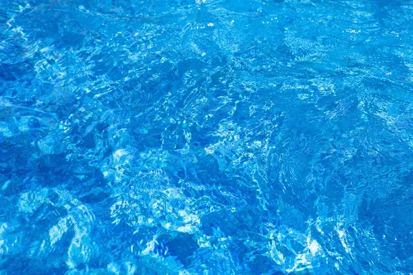 Ondulaciones de agua en la piscina, fondo azul —  Fotos de Stock