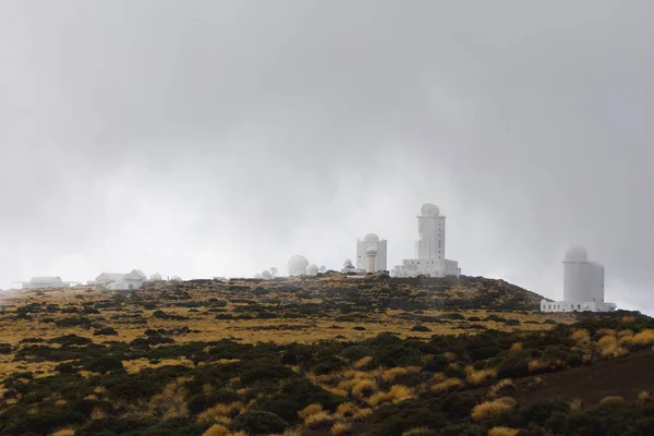 Teide Observatory astronomical telescopes in Tenerife, dense clouds background Stock Photo