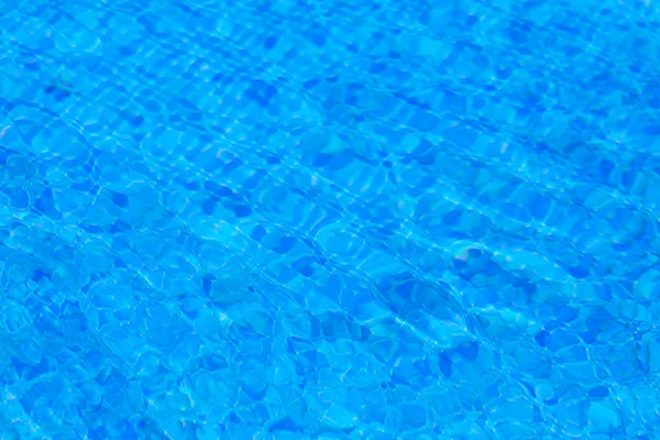 Water ripples in swimming pool, blue background — Stock Photo, Image