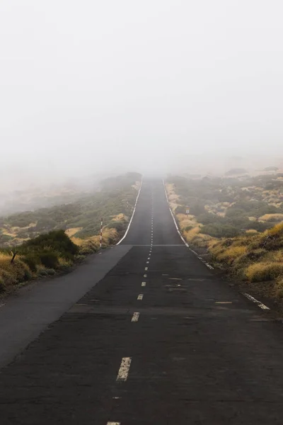 Górska droga z gęstymi chmurami mgły — Zdjęcie stockowe