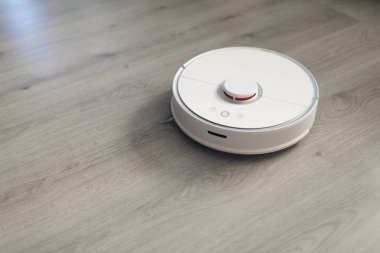 Plastik zeminde robotik elektrik süpürgesi çalışıyor.