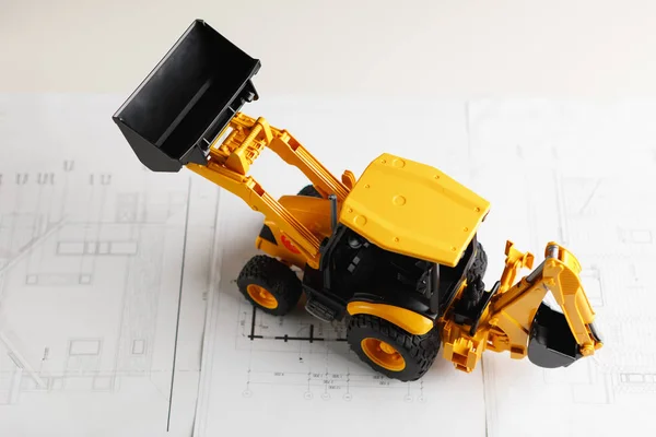 Tractor toy on housing construction blueprint — Stock Photo, Image