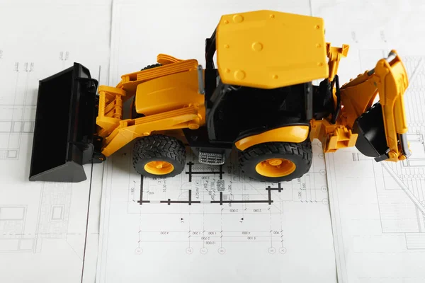 Traktor-Spielzeug auf Wohnungsbau-Blaupause — Stockfoto