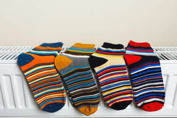 Gestreifte Socken werden auf dem Heizkörper getrocknet — Stockfoto