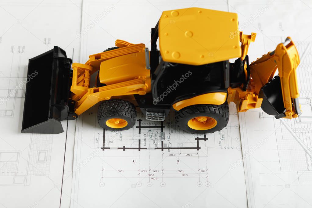 tractor toy on housing construction blueprint