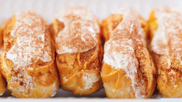 Eclairs pastelaria em uma caixa de plástico, vista close-up — Fotografia de Stock