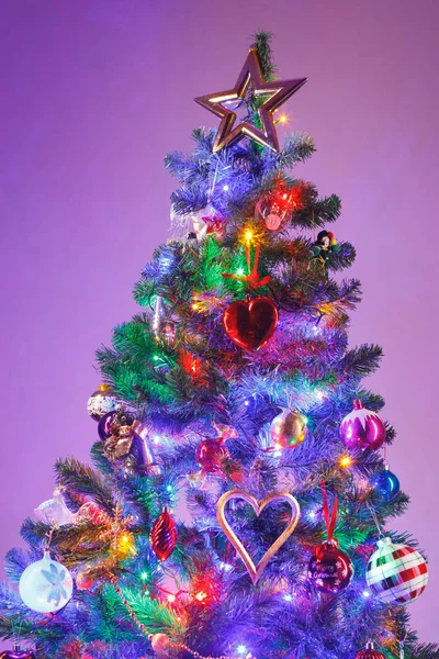 Árvore de Natal com luzes led multicoloridas e fundo roxo — Fotografia de Stock