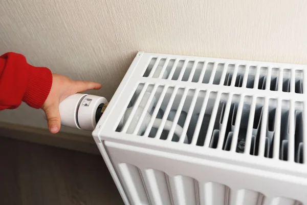 Kind hand regelt thermostatische knop van verwarming radiator — Stockfoto