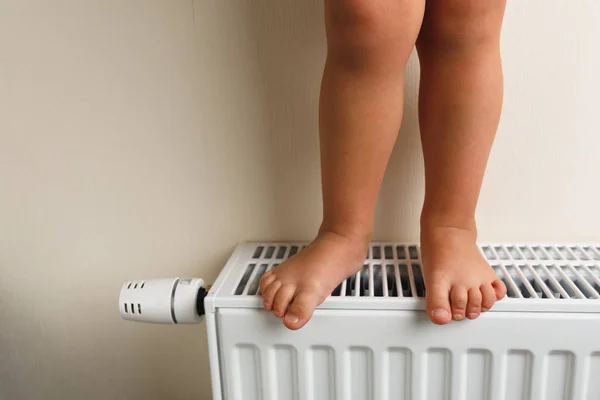 Kindervoeten op radiator, close-up zicht — Stockfoto