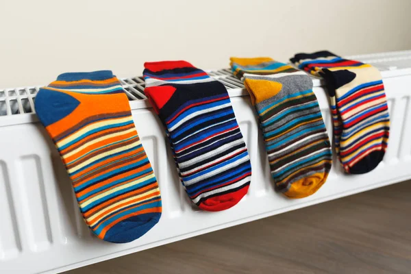 Colorful socks are being dry on the radiator — Stock Photo, Image