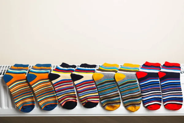 Colorful socks are being dry on the radiator — Stock Photo, Image