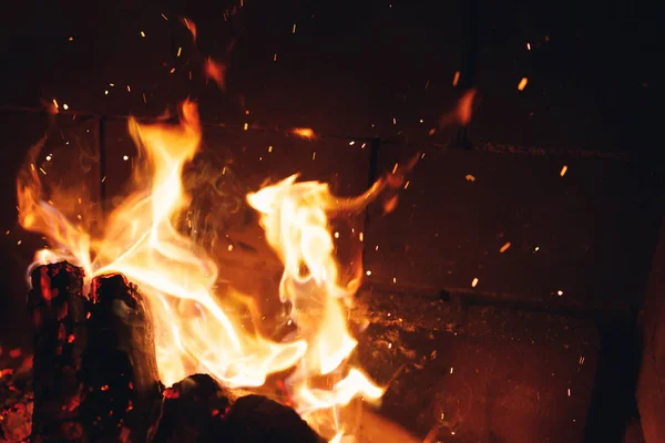 Grumes de feu brûlant avec des étincelles dans la cheminée — Photo