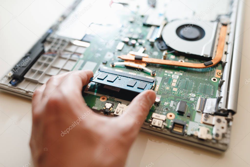 hand of repairman holding a ram sodimm memory module, laptop upgrade 