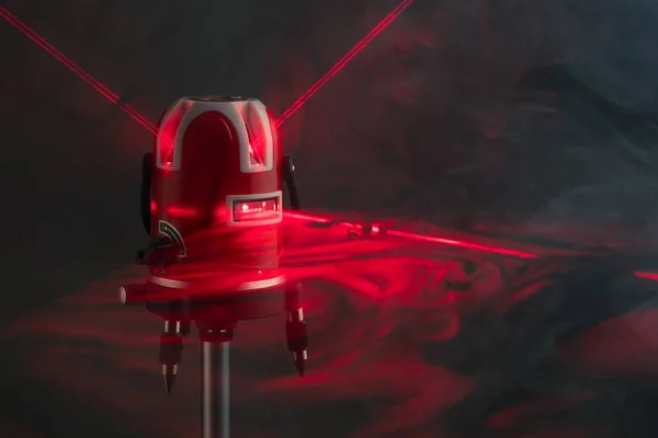 Strumento di livello laser raggi di luce rossa in fumo — Foto Stock