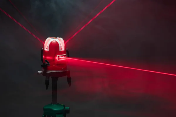 Laser level tool red light beams in smoke — Stock Photo, Image