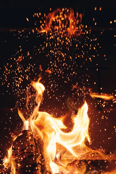 Grumes de feu brûlant avec des étincelles dans la cheminée — Photo