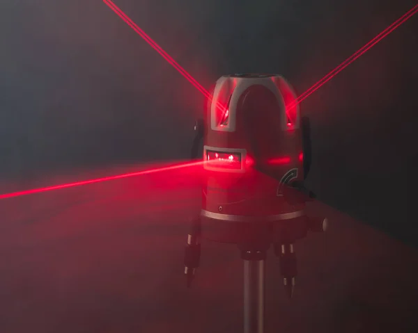 Narzędzie poziomu lasera czerwone belki świetlne w dymie — Zdjęcie stockowe