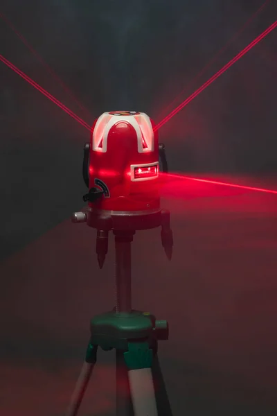Narzędzie poziomu lasera czerwone belki świetlne w dymie — Zdjęcie stockowe