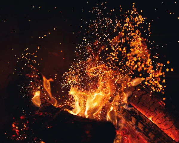 Grumes de feu brûlant avec des étincelles dans la cheminée — Photo