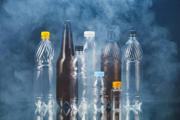Variedade de garrafas de plástico em fumaça, conceito de poluição — Fotografia de Stock