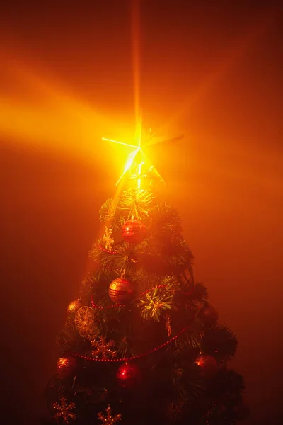 圣诞树，灯火通明，橙色背景，雾气弥漫 — 图库照片