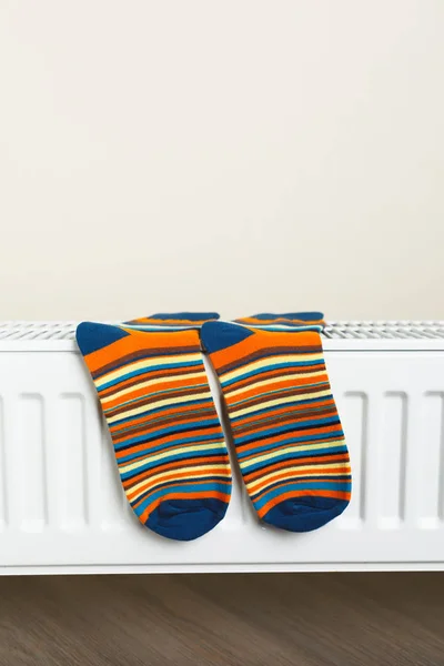Bunte Socken werden am Heizkörper getrocknet — Stockfoto