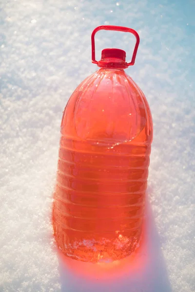 Garrafa com líquido de lava pára-brisas não congelante, fundo de neve — Fotografia de Stock