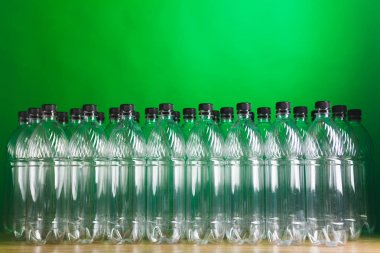 empty plastic bottles on green background clipart