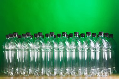 empty plastic bottles on green background clipart