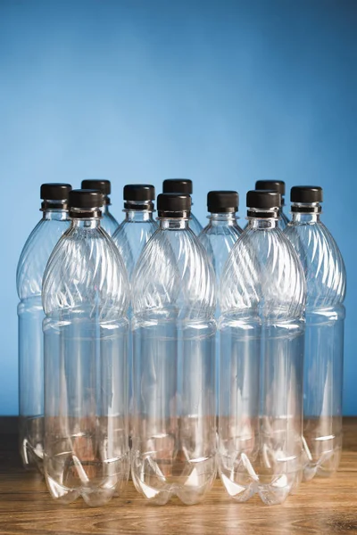 Tomma plastflaskor på blå bakgrund — Stockfoto