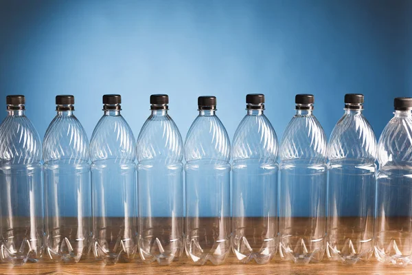 蓝色背景上的空塑料瓶 — 图库照片