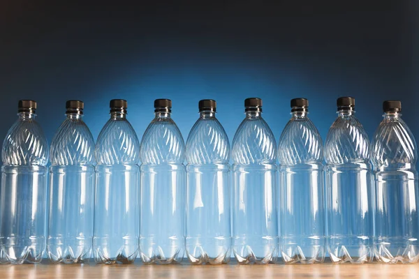 Leere Plastikflaschen auf blauem Hintergrund — Stockfoto