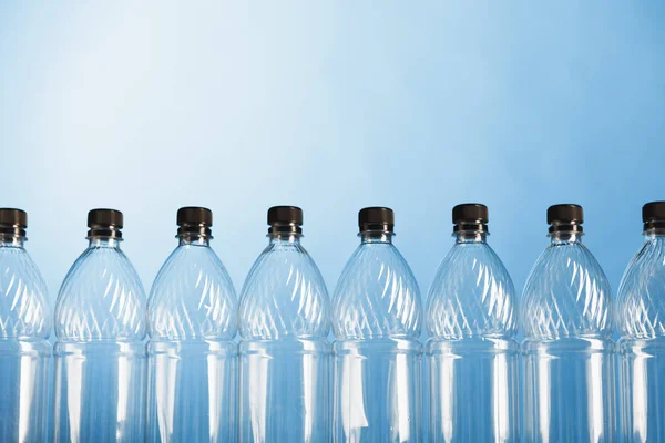 Empty plastic bottles on blue background — Stock Photo, Image