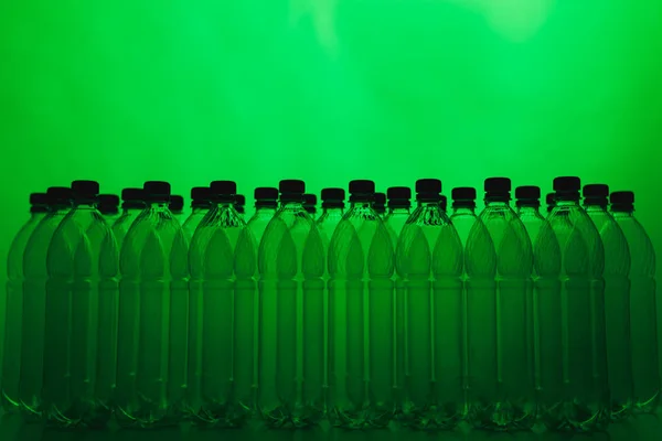 Siluetas de botellas de plástico vacías sobre fondo verde —  Fotos de Stock