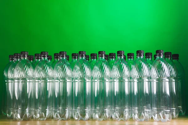 Tomma plastflaskor på grön bakgrund — Stockfoto