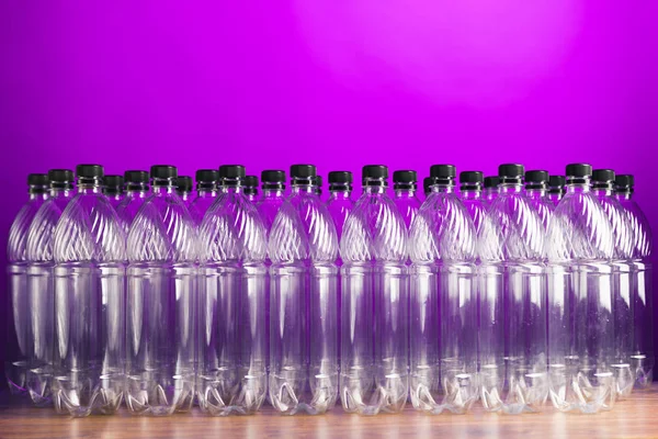Bottiglie di plastica vuote su sfondo viola — Foto Stock