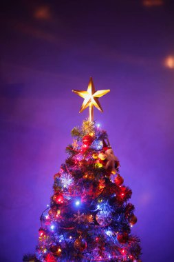 Festival yıldız, mor arka plan ile Noel ağacı