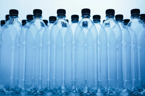 Пустые силуэты пластиковых бутылок на синем фоне — стоковое фото