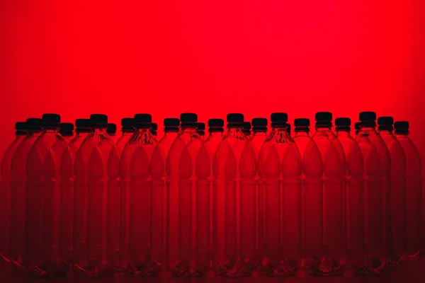 Silhuetas de garrafa de plástico vazias no fundo vermelho — Fotografia de Stock